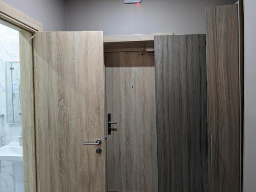 a bathroom with two wooden doors in a room at Victoria Hotel in Uralsk