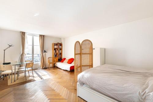 une chambre avec un lit, un bureau et une table dans l'établissement GuestReady - Sunlit Serenity near Montmartre, à Paris