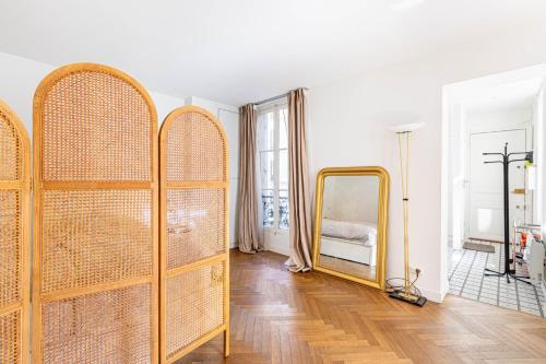 Cette chambre comprend un miroir et un lit. dans l'établissement GuestReady - Sunlit Serenity near Montmartre, à Paris