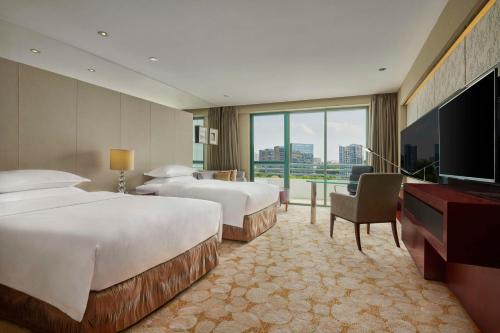 a hotel room with two beds and a flat screen tv at Hilton Guangzhou Science City, Free Shuttle Bus during Canton Fair in Guangzhou