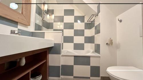 a bathroom with a black and white checkered wall at Argousiers 123 in Fort-Mahon-Plage