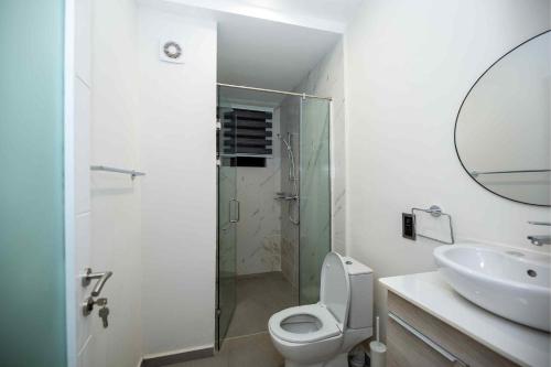 a bathroom with a shower and a toilet and a sink at Park Apartments in Accra