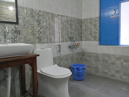 a bathroom with a white toilet and a sink at Glampinn Woods in Nainital