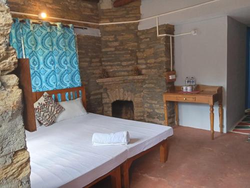 a bed in a room with a stone fireplace at Glampinn Woods in Nainital