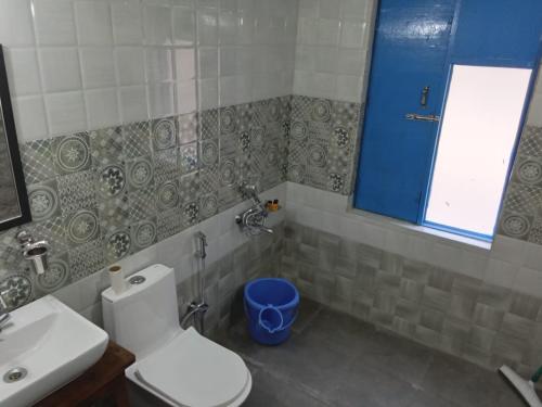 a bathroom with a toilet and a sink at Glampinn Woods in Nainital