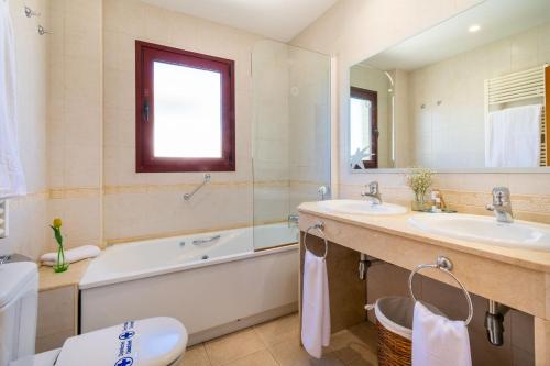 a bathroom with a tub and two sinks and a bath tub at Apartamentos Albir Confort - Avenida 1 dorm in Albir