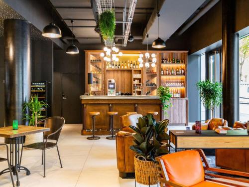 un restaurante con un bar con mesas y sillas naranjas en ibis Styles Puteaux Paris La Defense en Puteaux