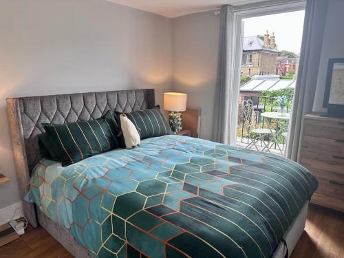 a bedroom with a bed and a large window at Room with balcony overlooking a garden in London