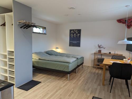 a bedroom with a bed and a table in a room at Compact Apartment Hvidager in Albertslund