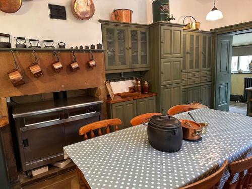 a kitchen with a table and a stove in it at Victorian Copper Cottage in Lancaster