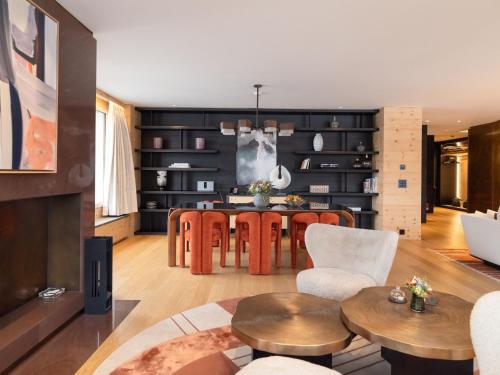 a living room with a table and chairs at Kulm Hotel St. Moritz in St. Moritz