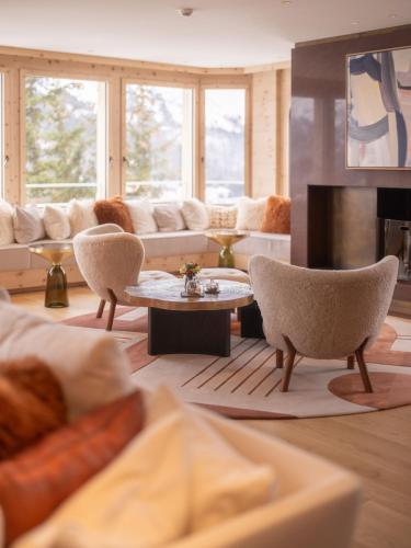 a living room with a couch and a table at Kulm Hotel St. Moritz in St. Moritz