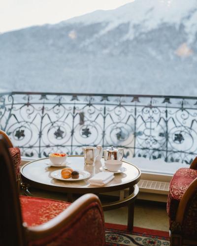 a table with a plate of food on a balcony at Kulm Hotel St. Moritz in St. Moritz