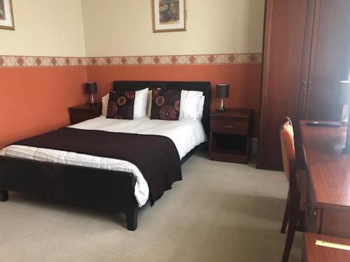 a bedroom with a large bed and a desk at The Edwardian Lodge Guest House in Salisbury
