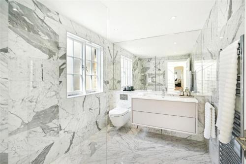 a bathroom with a tub and a toilet and a sink at 4 bedroom home by Buckingham Palace in London