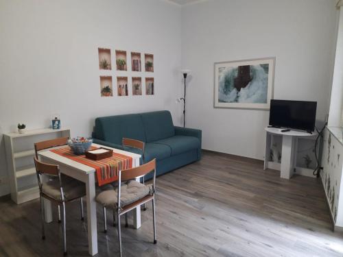 sala de estar con sofá azul y mesa en RiDi Home Zona Ospedaliera, en Nápoles