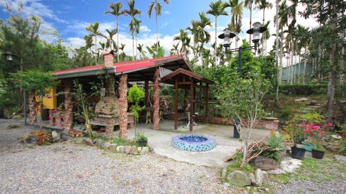 a small building with a blue fountain in a garden at Chin Pin Lo B&B in Yuchi