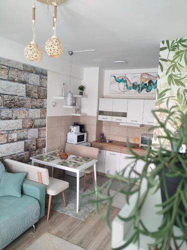 a kitchen and living room with a table and a couch at Apartment Tropical - Aqua Park Jagodina in Jagodina