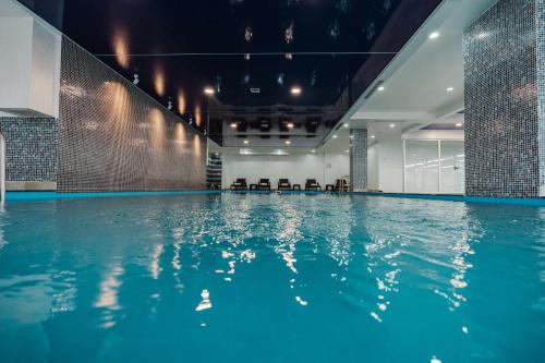 an indoor swimming pool with blue water at Best Western Plus Batumi in Batumi