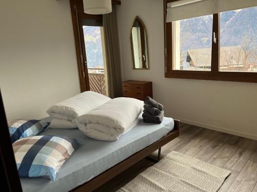 a bedroom with a bed with pillows and a window at Gemütliche Wohnung in Seelisberg in Seelisberg