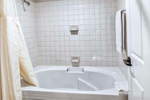 a white bath tub in a white tiled bathroom at Hilton Vacation Club Varsity Club Tucson in Tucson