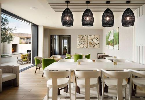 a restaurant with white tables and green chairs at The Knoll Hotel Napa Valley, Tapestry Collection by Hilton in Napa
