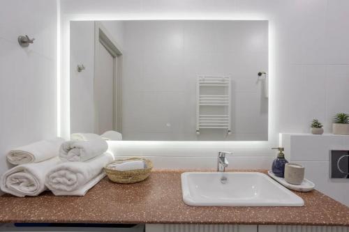 a bathroom counter with a sink and a mirror at Eli's Cozy Apartment in Tbilisi City