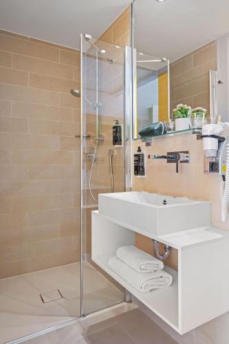 a bathroom with a sink and a shower at Hey Lou Hotel Hildesheim in Hildesheim