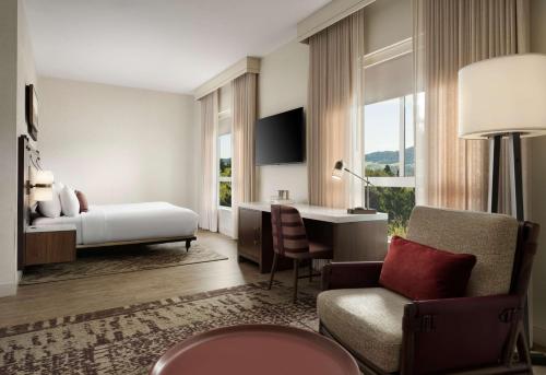 a bedroom with a bed and a desk and a chair at The Knoll Hotel Napa Valley, Tapestry Collection by Hilton in Napa