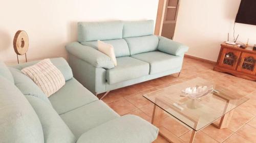 - un salon avec un canapé et une table en verre dans l'établissement Flamingo Vila Alicante, à San Pedro del Pinatar