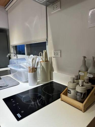 伊洛伊洛的住宿－Cozy 2 Bedroom End Unit，厨房柜台配有炉灶和餐具