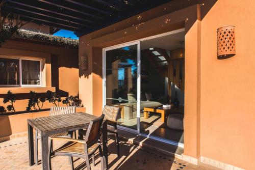 a patio with a table and chairs on a house at Paradis Plage Surf Yoga & Spa in Taghazout