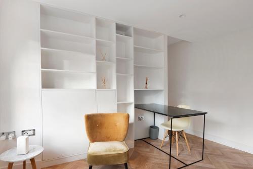 a desk and a chair in a room with white shelves at LUXURY NEW 1 bed SUITE BOND ST APART’M MAYFAIR in London