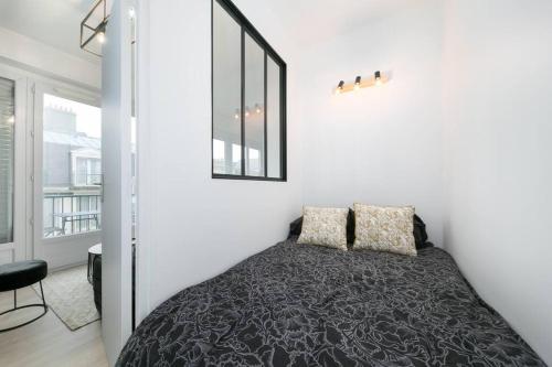 une chambre avec un lit et un miroir au mur dans l'établissement Appartement cosy 4 personnes vue mer DINARD centre, à Dinard
