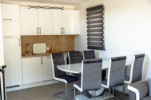 a kitchen with a table and black chairs at ARIA DELUXE Mobile Homes with Terme Čatež Tickets in Čatež ob Savi