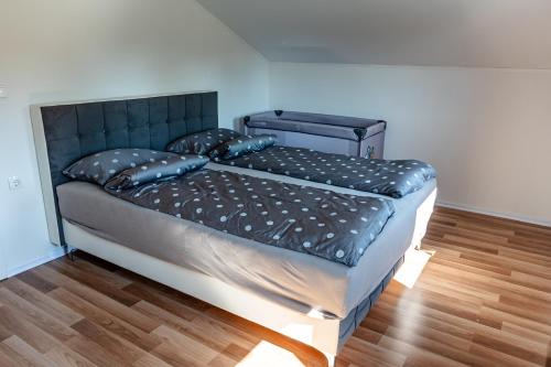 a bed with a black headboard and pillows on it at ARIA DELUXE Mobile Homes with Terme Čatež Tickets in Čatež ob Savi