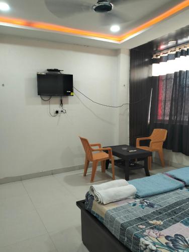Pokój z łóżkiem i telewizorem na ścianie w obiekcie Darbar Palace w mieście Gaja
