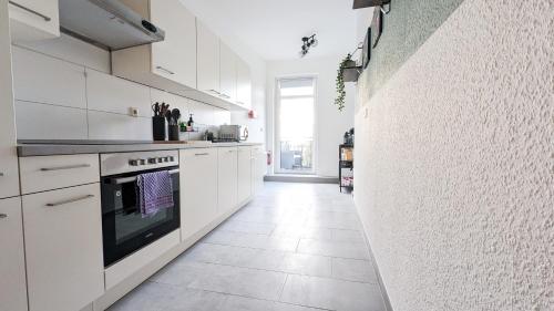 a kitchen with white cabinets and a stove at Sali-Homes Boarding Haus Monteur-Wohnungen Balkon Vollküche Autobahnähe in Markranstädt