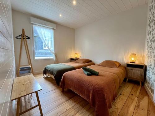 1 dormitorio con 2 camas y ventana en Maison hyper centre Ville - 4 Pers - 2 places de Parking gratuites, en Quimper