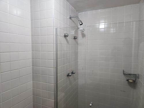 uma casa de banho com um chuveiro com azulejos brancos em Suíte 5 estrelas Hotel Moema Times Square 1412 em São Paulo