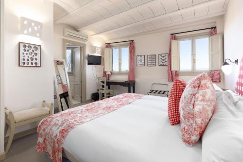 a bedroom with a large white bed with red pillows at Maison Muralleta B&B in Riba-Roja De Turia