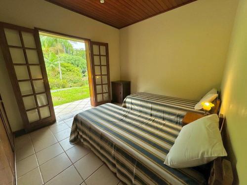 1 Schlafzimmer mit 2 Betten und einem großen Fenster in der Unterkunft Casa de campo para relaxar in Nova Friburgo