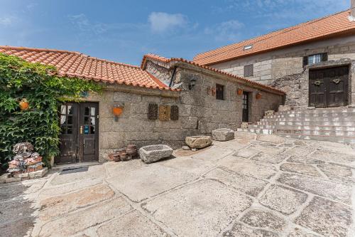 a stone house with a stone patio and a building at Casa Museu da Geada in Cinfães