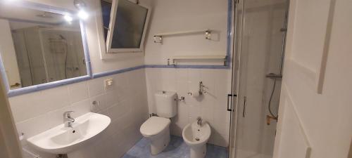 bagno con lavandino, servizi igienici e specchio di Villa Suk a Taormina