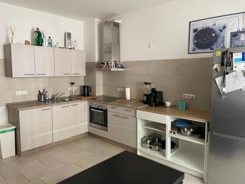 a kitchen with white cabinets and a stainless steel refrigerator at Im Herzen von Bochum in Bochum