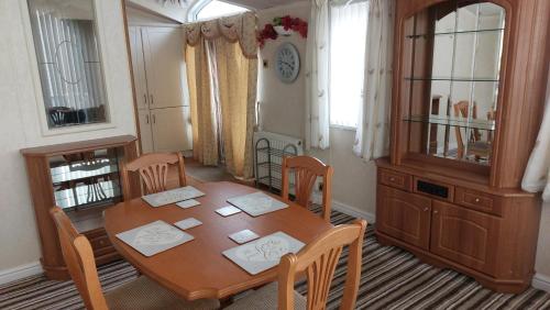 a dining room with a wooden table and chairs at 2 bedroom caravan near Llanberis, on the edge of Snowdonia in Llanddeiniolen