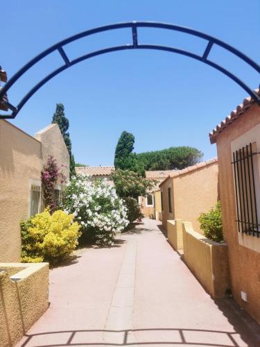 an arbor over a walkway between two buildings at Résidence l'Oustal des Mers in Gruissan