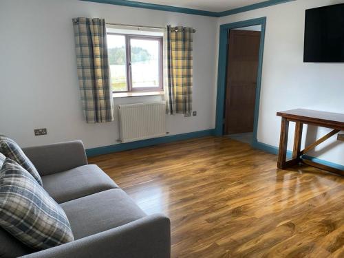 ein Wohnzimmer mit einem Sofa und einem Tisch in der Unterkunft Kingarth Hotel in Kilchattan