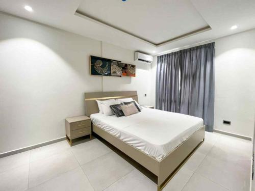 a bedroom with a large white bed in a room at Park Apartments in Accra