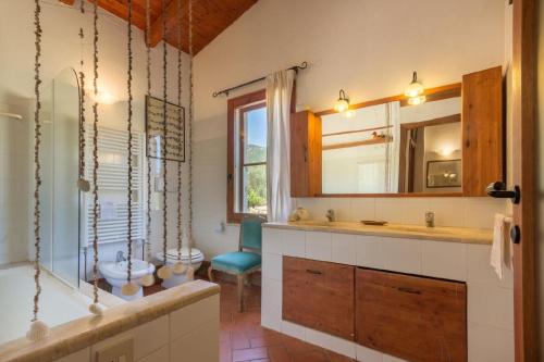 W łazience znajduje się wanna, umywalka i lustro. w obiekcie Ferienhaus für 5 Personen ca 90 qm in Castiadas, Sardinien Sarrabus Gerrei w mieście Castiadas